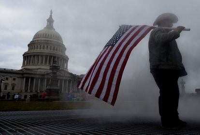 Un seguidor de Donald Trump sujeta una bandera de los Estados Unidos frente al Congreso, antes de la sesión en la que Mike Pence ratificará el triunfo de Joe Biden como presidente de EE UU.