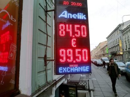 Un home passa per davant d'una oficina de canvi de divises a Moscou, Rússia, on es mostra la caiguda del ruble