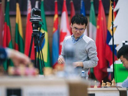Yangyi Yu mira la posición de su partida con Liren Ding mientras pasea por la sala durante el turno de juego de su rival