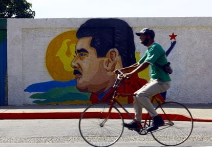 Un hombre pasa junto a un mural del presidente venezolano, Nicolás Maduro.