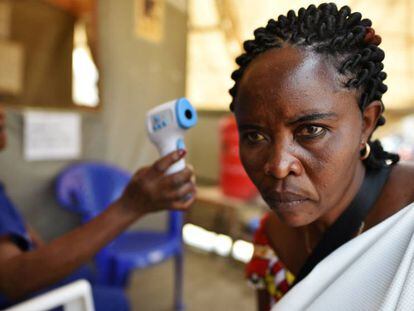 Una sanitaria mide la temperatura de una mujer como parte del dispositivo por el ébola en el hospital general de Goma, en el Congo. En vídeo, la OMS declara emergencia internacional el brote de ébola de la República Democrática del Congo.