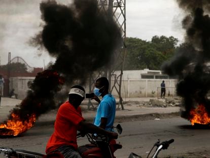 Supporters of former Senator Youri Latortue and Steven Benoit set tires on fire outside the court house in Port-au-Prince, Monday, July 12, 2021. Prosecutors have requested that high-profile politicians like Latortue and  Benoit meet officials for questioning as part of the investigation into the assassination of President Jovenel Moise. (AP Photo/Joseph Odelyn)