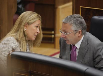 Trinidad Jiménez conversa con el ministro de Fomento, José Blanco, en el Congreso.