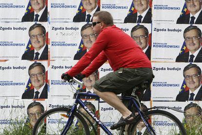 Un ciclista pasa ante carteles de la campaña electoral de Bronislaw Komorowski en una calle de Varsovia.