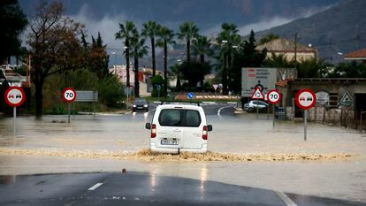 Una furgoneta intenta atravesar una vaguada inundada en una carretera a las afueras de Orihuela (Alicante).