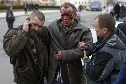 Transeúntes ayudan a una víctima de la explosión en el metro de Minsk.