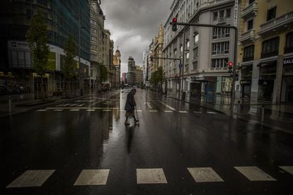Una mujer cruza un paso de peatones en la Gran Vía madrileña el 23 de marzo de 2020, en estado de alarma.