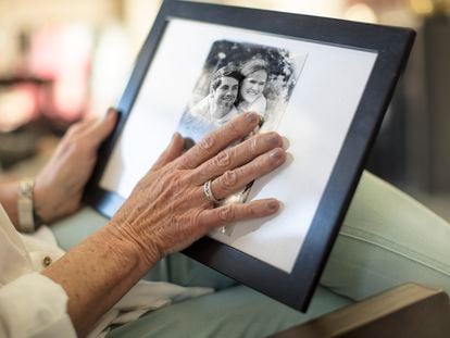 Una mujer mirando una fotografía de su familia.