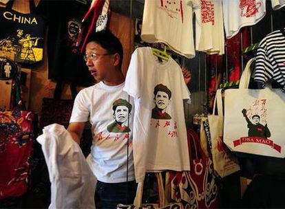 Un vendedor chino muestra las camisetas con el rostro de Barack Obama sobre la figura de Mao Zedong.