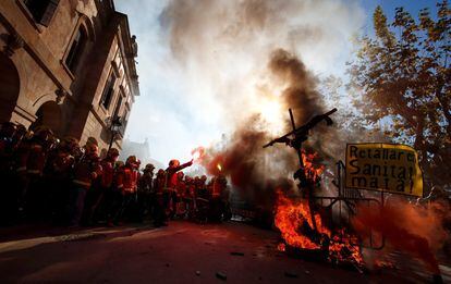 Los bomberos se han unido a la protesta de los médicos frente al Parlamento catalán. En la imagen, un bombero levanta una bengala durante una protesta contra los recortes y las condiciones de trabajo.