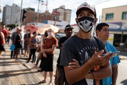 Un hombre espera para recibir un subsidio del Gobierno por la pandemia en São Paulo, Brasil.