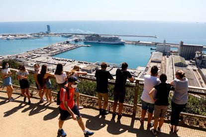 Turistas observando el MSC Grandiosa, atracado en el Puerto de Barcelona.