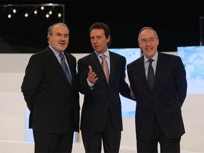 Pedro Solbes (izquierda) y  Manuel Pizarro (derecha) posan junto al moderador del debate, Matías Prats.