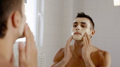 Un hombre se coloca una mascarilla para el cuidado facial.