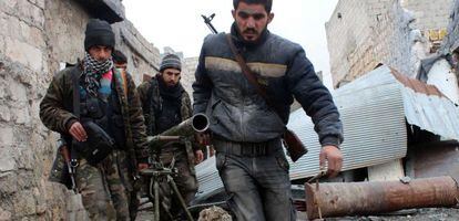 Combatientes rebeldes sirios cargan un lanza mortero, en Alepo el pasado enero.