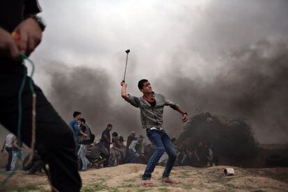 Un manifestante palestino lanza piedras utilizando una honda durante enfrentamientos con soldados israelíes en la frontera de Israel con Gaza en Bureij.