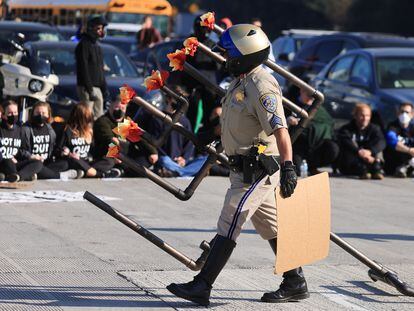 Un policía retira de la carretera una menorah utilizada por los manifestantes que exigen un cese al fuego en Gaza.