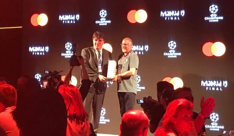 El secretario general de la UEFA Theodore Theodoridis hace entrega de un galardón a Mastercard por sus 25 años apoyando la competición.