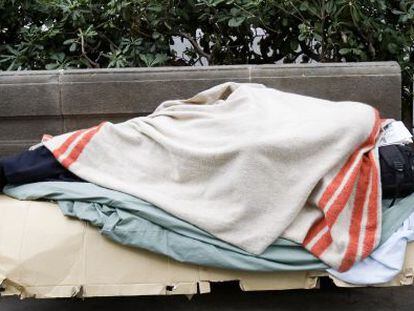 Un sense sostre dormint en un banc de Barcelona.