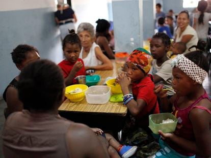 Un grupo de niños recibe alimentos en una cocina comunitaria financiada por una ONG, en Caracas (Venezuela).