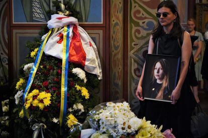 Una amiga de Victoria Amelina sostiene su retrato durante el funeral.