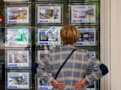 Una mujer mira la oferta de viviendas en una inmobiliaria.