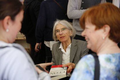 La escritora estadounidense Donna Leon entrega un libro firmado a un lector.