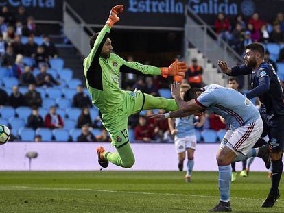 Diego López, meta del Espanyol, trata de despejar la pelota ante Maxi Gómez