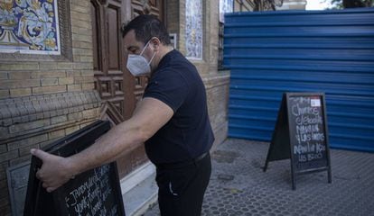 Camareros recogiendo las mesas de el bar de Triana (Sevilla).