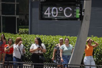 People walk on Paulista Avenue, where urban thermometers register a temperature of 40.0 degrees Celsius, this Tuesday, in the city of São Paulo (Brazil). 