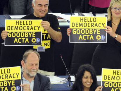 Eurodiputados de Los Verdes muestran carteles con el mensaje &quot;Hola democracia. Adi&oacute;s Acta&quot;.