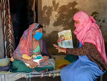 Reena Patidar, activista de una asociación en favor de la lactancia materna, explica los beneficios de la misma a Latha Raju Masaur en Jethana, un pueblo de India.