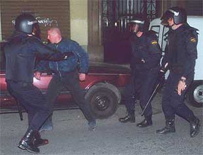 Tres policías rodean a un manifestante ultraderechista en Valencia.