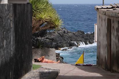 Una mujer toma el sol en Güímar en Tenerife, uno de los trece municipios declarados en alerta roja por altas temperaturas en la isla durante la jornada de este jueves. 
