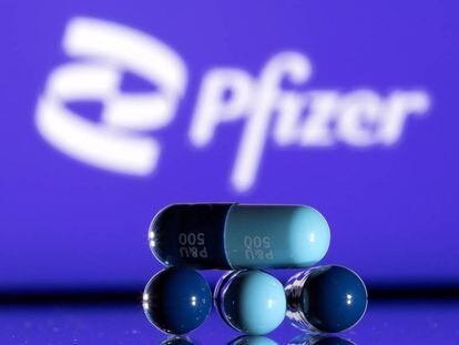 El logo de Pfizer junto a unas píldoras fabricadas por la empresa
