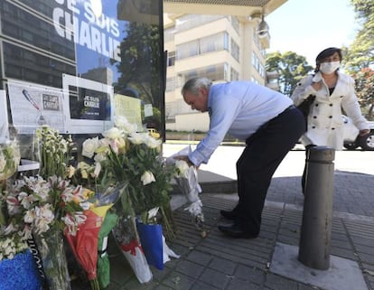 Un expatriado francés pone un ramo de flores ante la embajada gala en Bogotá, en Colombia.