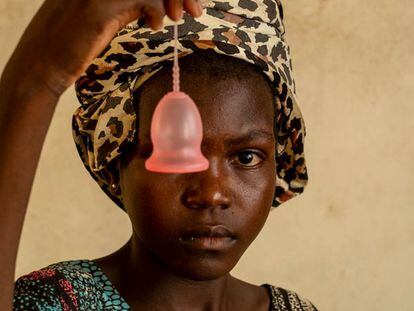 Una niña posa con una copa menstrual, un producto que puede ayudar a las adolescentes de países con problemas de agua a conseguir mejor higiene durante los días de regla.