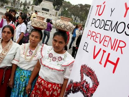 Tres mujeres junto a un cartel con la frase "Tú y yo podemos prevenir el VIH", durante el Día Mundial del sida, en Lima (Perú).