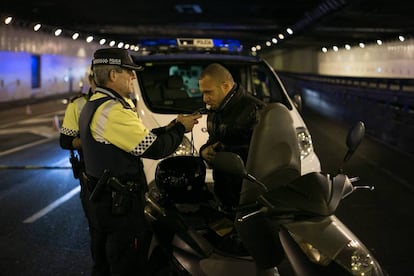 Un agente de la Guardia Urbana de Barcelona hace la prueba de alcoholemia a un motorista, en diciembre pasado.
