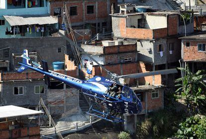 Miembros de la Policía Militar patrullan en helicóptero la favela da Grota en el Complejo del Alemán en Rio de Janeiro (Brasil).