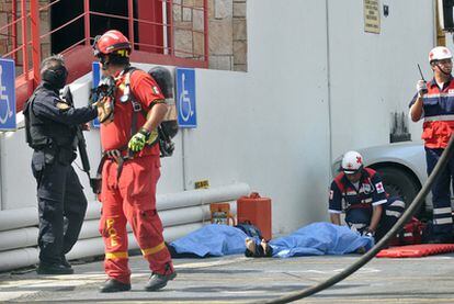 Un miembro de Cruz Roja cubre los cuerpos de dos víctimas en el exterior del casino.