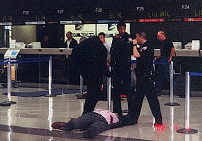 Guardias de seguridad, junto al cadáver del egipcio que abrió fuego el pasado jueves en el aeropuerto de Los Ángeles.