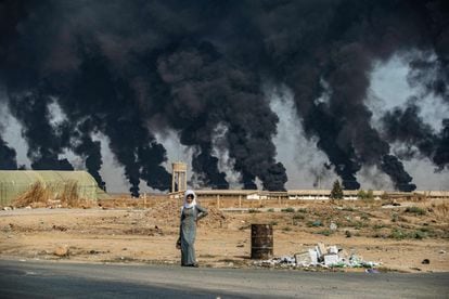 Una mujer espera en una carretera de la ciudad de Tal Tamr, al noreste de Siria, el 16 de octubre de 2019. Según un comunicado del presidente turco, Recep Tayyip Erdogan, “las Fuerzas Armadas turcas, junto con el Ejército Nacional Sirio [rebeldes anteriormente vinculados al Ejército Libre Sirio] lanzaron la Operación Manantial de Paz contra los terroristas del PKK-YPG y el Daesh [Estado Islámico] en el norte de Siria”.