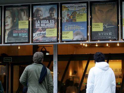 Dos personas contemplan la cartelera de un cine madrileño.