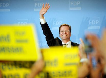 Guido Westerwelle, líder de los liberales, saluda a sus partidarios tras conocerse los primeros datos.