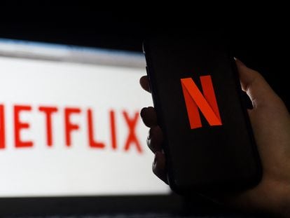Logo de Netflix en la pantalla de un teléfono móvil y de un ordenador.