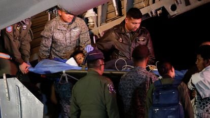 Personal militar descarga de un avión a uno de los cuatro hermanos indígenas que estaban desaparecidos después de un accidente aéreo mortal en la base aérea militar de Bogotá, Colombia, el sábado 10 de junio de 2023.
