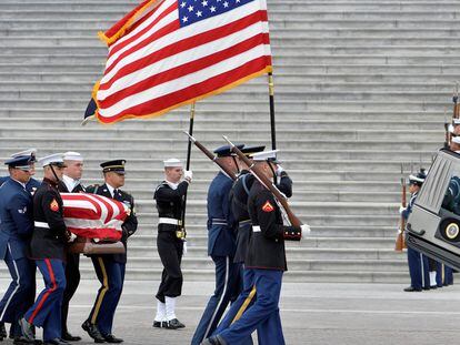 La guardia de honor militar lleva el ataúd del ex presidente George H.W. Bush hacia el coche fúnebre.