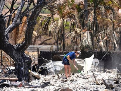 Una mujer cava entre los escombros de una casa destruida por el incendio forestal, este viernes 11 de agosto, en Lahaina (Hawái).