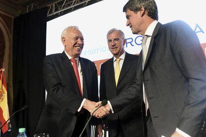 El ministro de Asuntos Exteriores de España, Jose Manuel Garcia-Margallo, saluda el ministro de Economía argentino, Alfonso Prat Gay. Los acompaña el presidente de la Cámara española de Comercio, Guillermo Ambrogi.